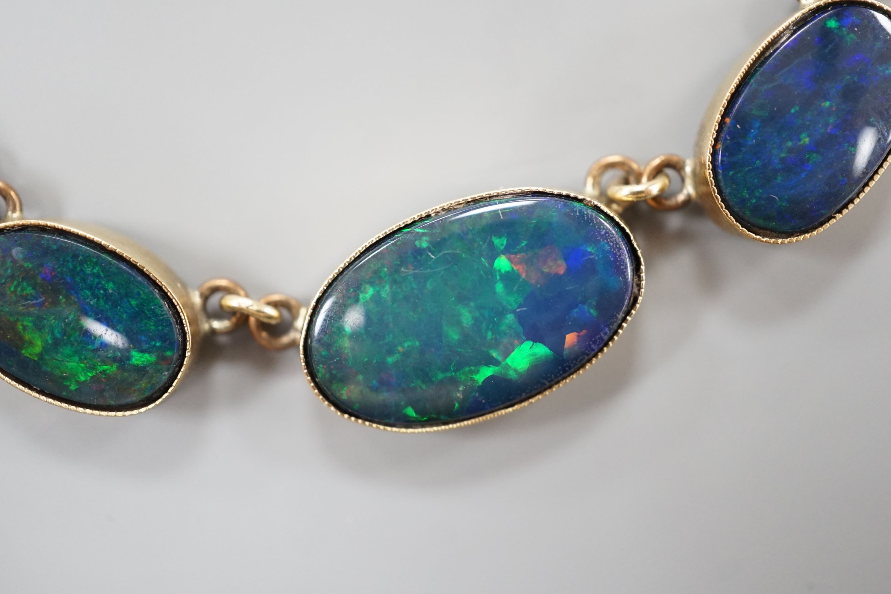A yellow metal and graduated oval opal doublet set fringe necklace, 48cm, gross weight 14.1 grams.